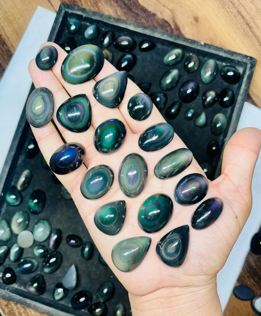 rainbow obsidian eye cabochons displaying bright blue, violet, and electric green concentric rings.