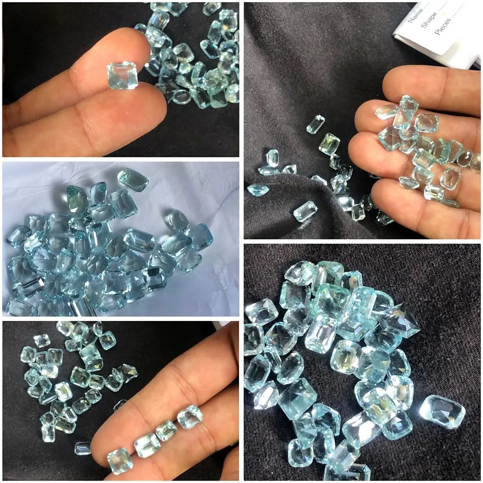 Wholesale lot of faceted emerald-cut aquamarine gemstones with icy sky-blue clarity.