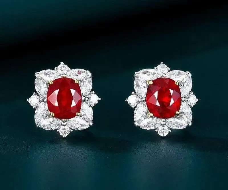 Matched pair of natural Burmese ruby and diamond halo earrings displaying vivid pigeon blood red color.