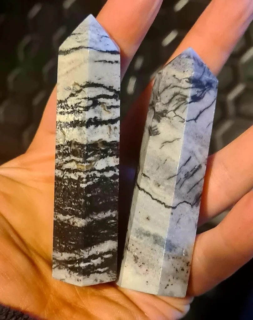 Natural spiderweb jasper crystal towers featuring high-contrast black and white matrix webbing for altar decor.