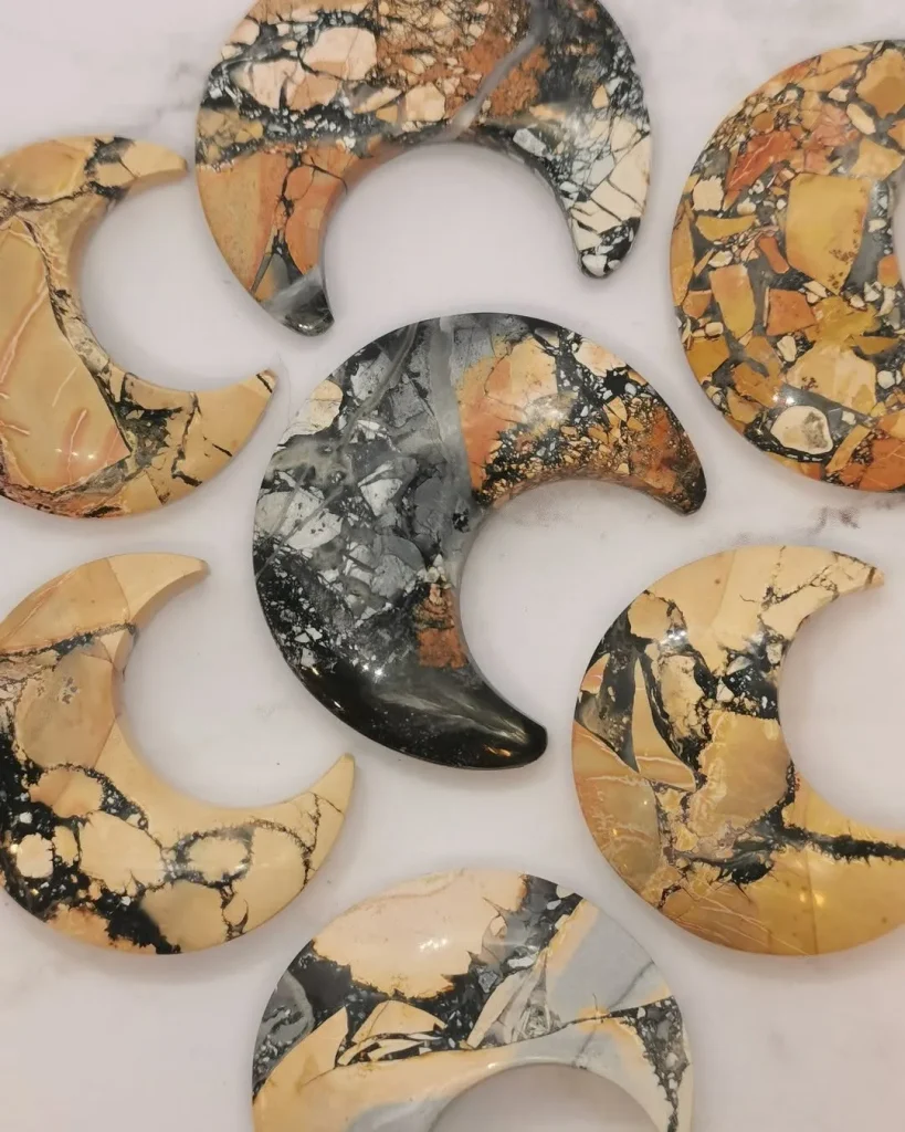 Natural Indonesian Maligano jasper hand-carved crescent moon crystal carvings showing brecciated yellow, orange, and black matrix patterns for altar decor.