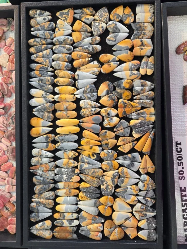 Wholesale parcel of natural polished Maligano jasper matched pair cabochons displaying brecciated yellow, orange, and slate-grey patterns for artisan earrings and jewelry making