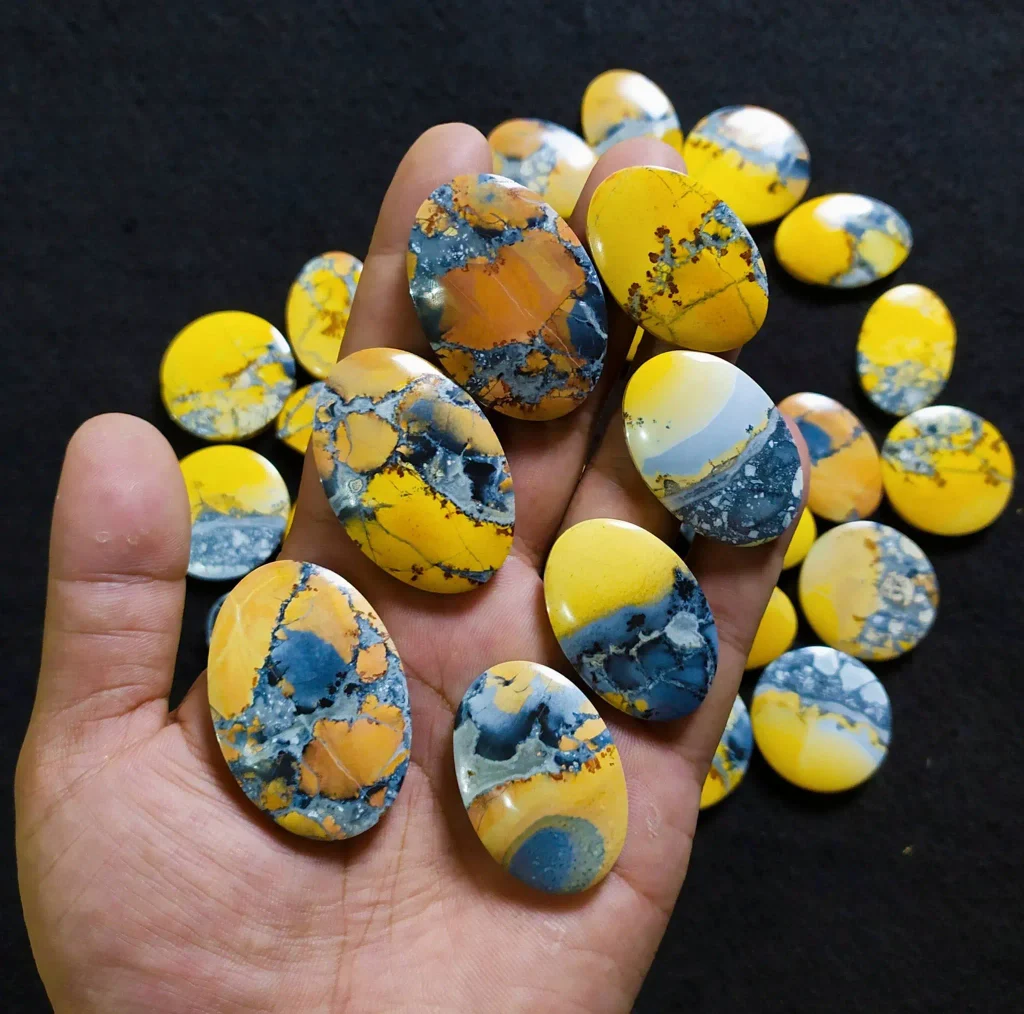 Natural polished Indonesian Maligano jasper oval cabochons showing brecciated mustard yellow, orange, and denim-blue agate patterns for jewelry making.