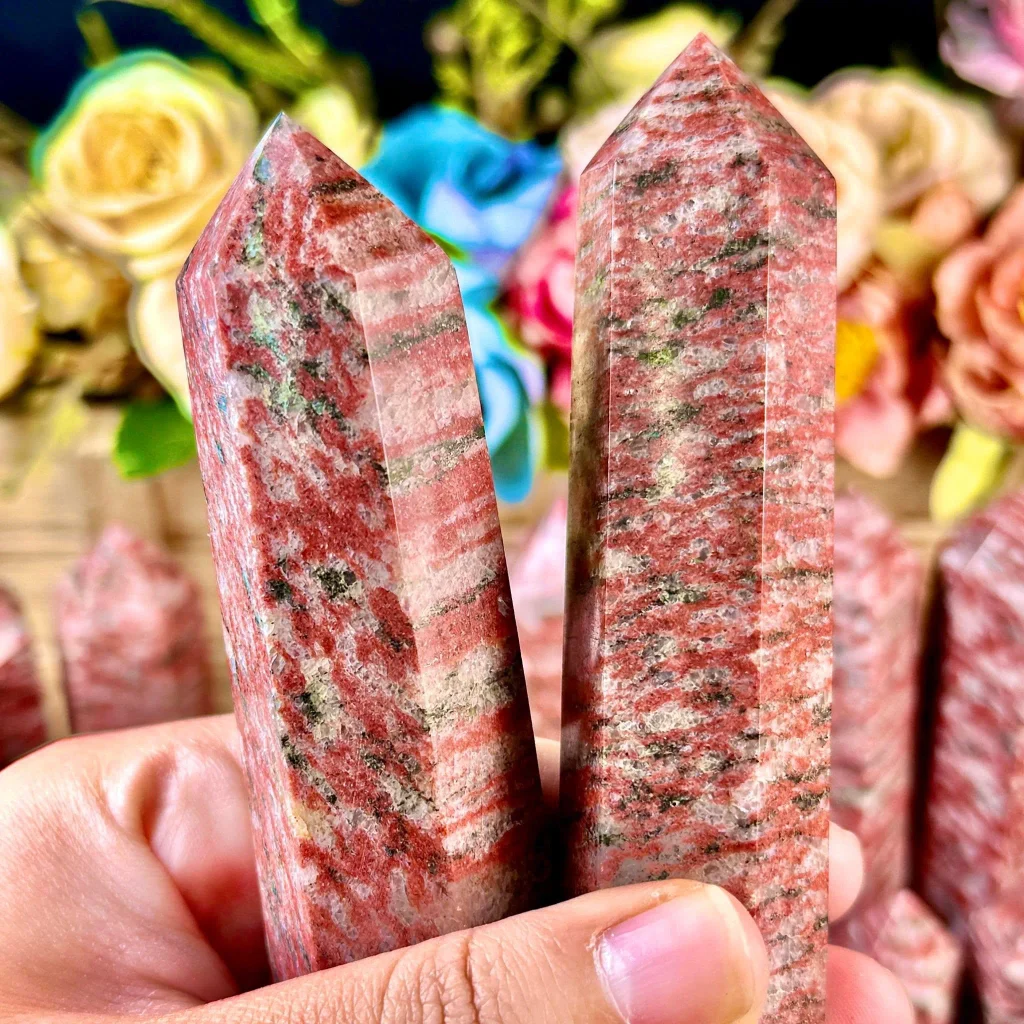 Natural polished red sesame jasper crystal points and generator towers displaying pinkish-red speckled bands for crystal healing and home decor.