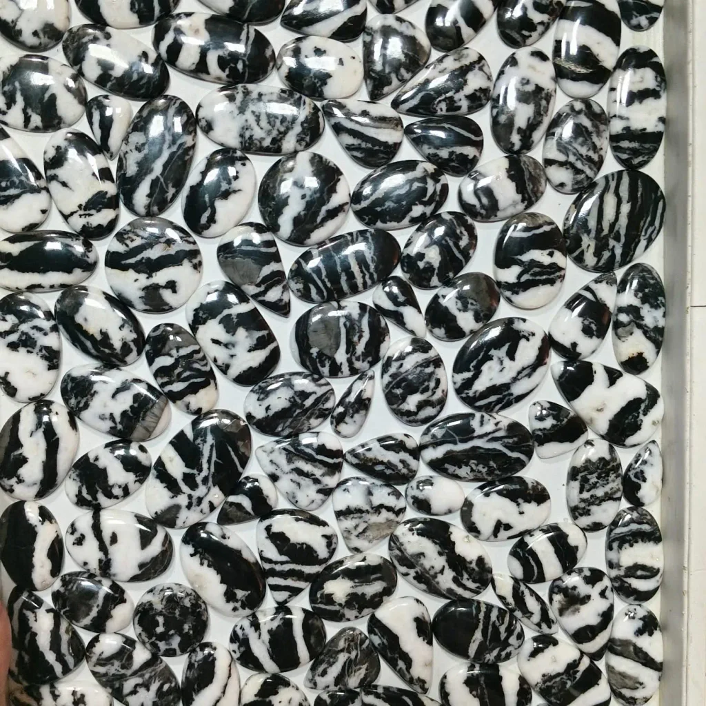 natural polished zebra jasper flat-back cabochons displaying bold black and white striped patterns for jewelry making.